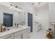 Bright bathroom with double vanity, modern fixtures, white tile floors, and marble tile in the shower at 1171 Eggleston Sw St, Atlanta, GA 30310