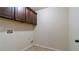 Well-lit laundry room with wall-mounted storage cabinets and tile flooring at 5669 Casa Blanca Ln, Atlanta, GA 30331