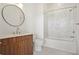 Bathroom with a modern vanity, round mirror, and tiled shower over tub at 675 Drewry Ne St # 201, Atlanta, GA 30306