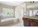 Luxurious bathroom featuring a soaking tub, granite vanity, and large window at 2953 Kings Walk Ave, Marietta, GA 30062