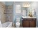 Bright bathroom showcasing a shower-tub combo with tiled walls, vanity with drawers, and a neutral color palette at 2953 Kings Walk Ave, Marietta, GA 30062