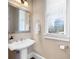 Bathroom featuring a pedestal sink, framed mirror, and a window with blinds for natural light at 2953 Kings Walk Ave, Marietta, GA 30062