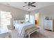 Bright bedroom features neutral colors, a ceiling fan, carpet, and a bench seat at the end of the bed at 2953 Kings Walk Ave, Marietta, GA 30062