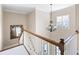 Stairway with white railings, hardwood trim, a hanging light fixture, and a decorative mirror on the wall at 2953 Kings Walk Ave, Marietta, GA 30062