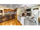 Open living room featuring a stone fireplace, hardwood floors, and an adjacent kitchen area at 2953 Kings Walk Ave, Marietta, GA 30062