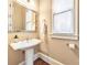 Bright powder room featuring a pedestal sink, decorative mirror, and natural light at 2953 Kings Walk Ave, Marietta, GA 30062