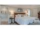 Bright bedroom with a large bed, bedside table, and decor; view of a hallway and bathroom at 3673 Howard Dr, College Park, GA 30337