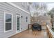 View of the cozy deck with a grill, adjacent to the house's gray exterior with a glass door at 3673 Howard Dr, College Park, GA 30337