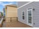 View of the cozy deck with a wooden railing, adjacent to the house's gray exterior with a glass door at 3673 Howard Dr, College Park, GA 30337