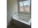 Bright bathroom featuring a soaking tub with a large window view at 4373 Trake Way, Ellenwood, GA 30294