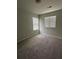 Bright bedroom featuring two windows for natural light and neutral carpeting at 4373 Trake Way, Ellenwood, GA 30294