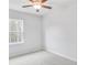 This bedroom features neutral carpet, a ceiling fan, and a window providing ample natural light at 6074 Marigold Way, Atlanta, GA 30349