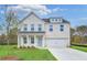 Charming two-story brick home featuring a manicured lawn and a light blue front door at 6074 Marigold Way, Atlanta, GA 30349