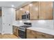 Modern kitchen with stainless steel appliances, quartz countertops, wooden cabinetry, and a gas range at 6074 Marigold Way, Atlanta, GA 30349