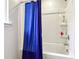 Full bathtub and shower with blue curtain and shampoo and soap shelves at 1405 Lyon Way Dr, Lawrenceville, GA 30044