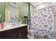 Bright bathroom features stylish wallpaper, a vanity, and a shower with a floral curtain at 1405 Lyon Way Dr, Lawrenceville, GA 30044