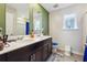 Bathroom features a double sink vanity with granite countertop, framed mirror, and a toilet near a window at 1405 Lyon Way Dr, Lawrenceville, GA 30044