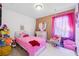 Colorful bedroom with a pink bed, a plush rug, and decorative accents at 1405 Lyon Way Dr, Lawrenceville, GA 30044