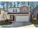 Charming two-story home with brick and stone accents, a two-car garage and a landscaped front yard at 1405 Lyon Way Dr, Lawrenceville, GA 30044
