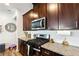 Modern kitchen features dark wood cabinetry, granite countertops, and stainless steel appliances at 1405 Lyon Way Dr, Lawrenceville, GA 30044