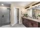 Bathroom with a double sink vanity, granite countertops, a tiled shower, and modern fixtures at 1985 Lois Pl, Atlanta, GA 30318