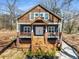 Charming two-story home featuring a welcoming elevated front porch with stairs and blue painted wood with cedar shake accents at 1985 Lois Pl, Atlanta, GA 30318
