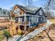 Two-story home featuring a welcoming elevated front porch with wooden stairs and blue painted wood with cedar shake accents at 1985 Lois Pl, Atlanta, GA 30318