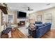 Bright living room boasts a stone fireplace, hardwood floors, a ceiling fan, and a comfortable blue sofa at 1985 Lois Pl, Atlanta, GA 30318