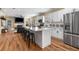Open living space featuring a sleek white kitchen, center island, and view of the living area with stone fireplace at 1985 Lois Pl, Atlanta, GA 30318