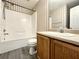 Bathroom featuring a vanity, a shower-tub combo with beige tile and striped wallpaper at 5916 Dogwood Mnr, Lithonia, GA 30038
