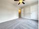 Bedroom featuring gray carpeting, ceiling fan, a closet, and a door to another room at 5916 Dogwood Mnr, Lithonia, GA 30038
