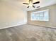 Cozy bedroom featuring neutral paint, gray carpet, large bay window, and modern ceiling fan at 5916 Dogwood Mnr, Lithonia, GA 30038
