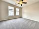 Bright bedroom with two windows, ceiling fan, neutral walls, and plush gray carpeting at 5916 Dogwood Mnr, Lithonia, GA 30038