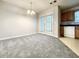 Spacious dining area with gray carpet, modern chandelier, and natural light from patio doors at 5916 Dogwood Mnr, Lithonia, GA 30038