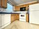 Cozy kitchen featuring laminate counters, classic oak cabinets, and white appliances at 5916 Dogwood Mnr, Lithonia, GA 30038