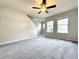 Bright living room featuring gray carpet, a modern ceiling fan, and ample natural light from windows at 5916 Dogwood Mnr, Lithonia, GA 30038