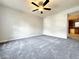 Bright living room featuring gray carpet, a modern ceiling fan, and ample natural light at 5916 Dogwood Mnr, Lithonia, GA 30038