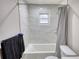 Bright bathroom featuring marble wall tiles, vanity, and tub with shower at 115 Hollybrook Rd, Atlanta, GA 30349