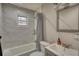 Bright bathroom featuring marble wall tiles, vanity, and tub with shower at 115 Hollybrook Rd, Atlanta, GA 30349