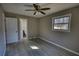 This is a bedroom with light gray walls, wood floors, ceiling fan, and a bathroom that is easily accessible at 115 Hollybrook Rd, Atlanta, GA 30349