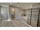 Open living space with wood-look floors, access to a bathroom, and a stainless steel refrigerator at 115 Hollybrook Rd, Atlanta, GA 30349