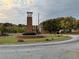 Community clock tower with brick base and manicured landscaping on a tree-lined street in a roundabout at 5027 Bayrose Cir # 27A, Atlanta, GA 30344