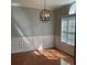 Elegant dining room featuring hardwood floors, a modern light fixture, wainscoting, and a window at 5027 Bayrose Cir # 27A, Atlanta, GA 30344