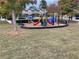 Community playground with slides, climbing structures, and a soft surface surrounded by green grass and trees at 5027 Bayrose Cir # 27A, Atlanta, GA 30344