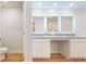 Modern bathroom featuring dual sinks, vanity area, white cabinets, and illuminated mirrors at 637 Egrets Landing #51, Covington, GA 30014