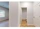 Hallway with wood floors leading to a view of a bathroom with a white shower at 637 Egrets Landing #51, Covington, GA 30014