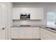 Modern kitchen with stainless microwave, granite counters, white cabinets, and subway tile backsplash at 637 Egrets Landing Lndg, Covington, GA 30014