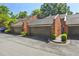Three car garages in a row on brick buildings with dark roofs and an asphalt driveway at 17 Willow Ne Gln, Atlanta, GA 30342