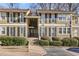 Inviting exterior of townhome featuring neutral siding, black shutters, and manicured landscaping at 5153 Roswell Rd # 10, Atlanta, GA 30342