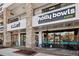 A street view of Holly Bowls & Bites, and Michael Evans Flowers in a retail strip featuring brick and dark metal design at 5153 Roswell Rd # 10, Atlanta, GA 30342